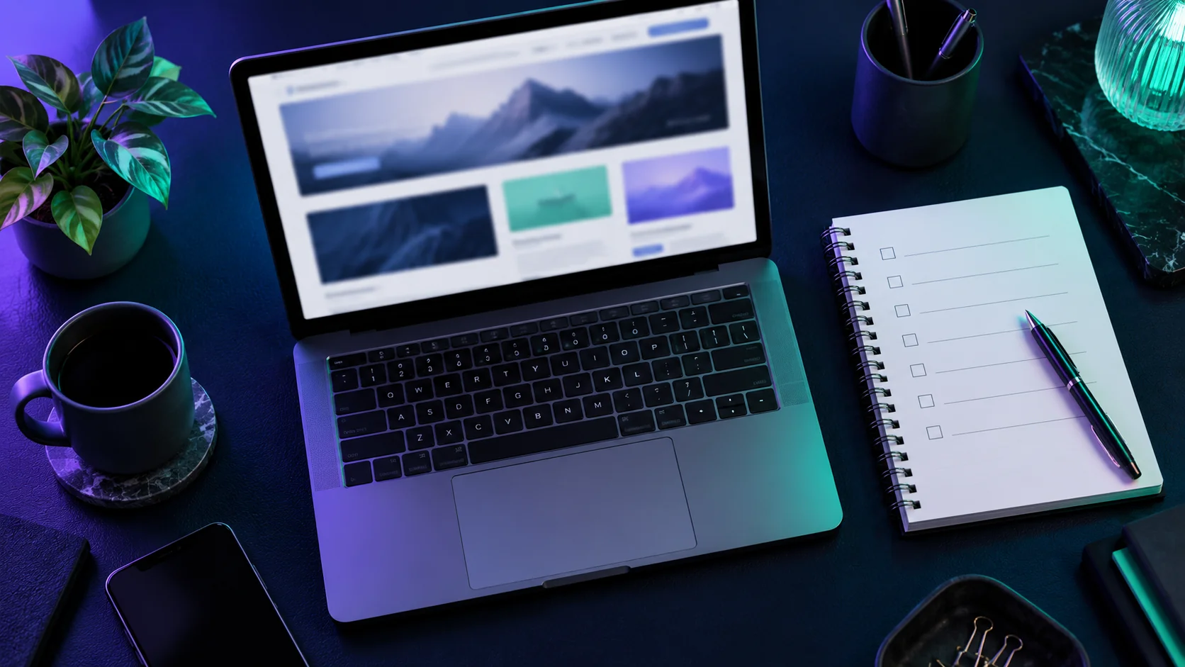 Ordenador y cuaderno de revisión sobre una mesa con iluminación violeta y verde.